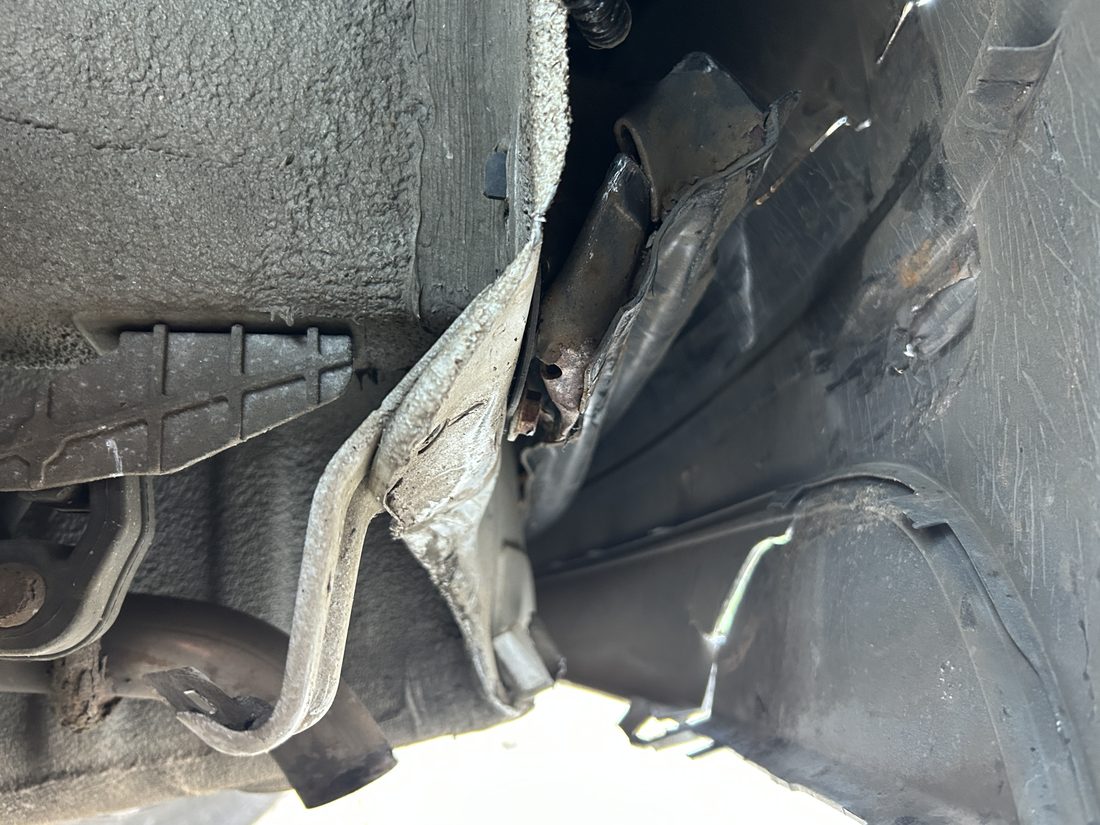 Verformter Längsträger hinten, daneben die aufgerissene Radhausschale